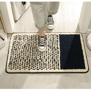 Detailed plush bathroom mat with beige polka dots and navy blue block on entryway floor