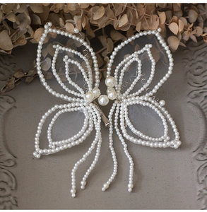 Détail de la pince à cheveux papillon faite main avec gaze et glands de perles