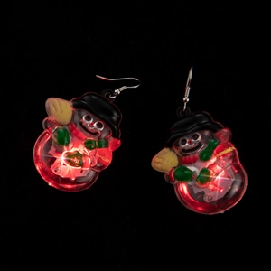 Detail showing glowing LED snowman earrings with red lights on a dark background