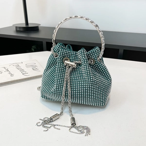 Détail du sac seau à strass verts avec poignées rondes argentées et décorations de franges