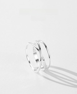 Macro detail of silver geometric cross ring with minimalist intertwined double lines