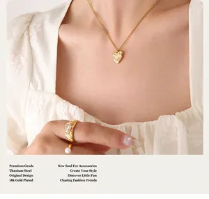 Close-up of 18k gold plated titanium steel heart necklace and pearl rings on model
