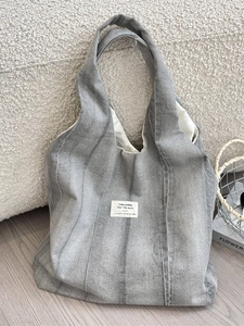 Trendy tie-dye grey denim canvas tote bag with large capacity shown on a cozy sofa