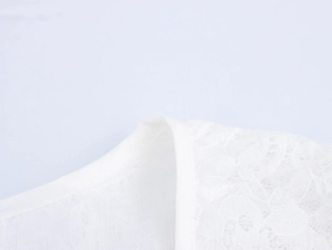 Détail de l'encolure en V avec dentelle blanche et bordure volantée sur robe longue