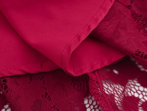 Gros plan sur la dentelle rouge et les coutures de la robe élégante à manches bouffantes