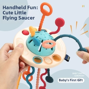 Detail of UFO-shaped sensory toy featuring colorful silicone pull strings and textures
