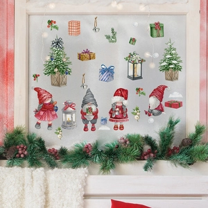 Close-up of festive Christmas gnomes and tree stickers on a frosted window glass