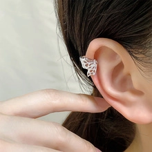 Detailed side view of a hollow butterfly ear cuff with intricate silver wing patterns