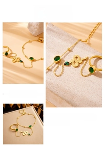 Detail of gold snake slave bracelet set with green gemstones and fine scale texture