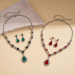 Vintage jewelry set with teardrop emerald and ruby pendants on gold necklaces