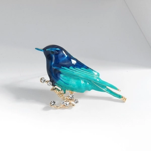 Minimalist enamel bird brooch with blue-green gradient and crystal branch on white background