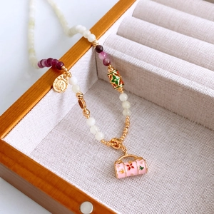 Vue macro d'un collier de perles à la française avec zircon et pendentif émaillé en boîte