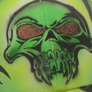 Close-up of neon green skull embroidery with orange sequins on cotton baseball cap