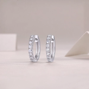 Macro shot of silver hoop earrings featuring pavé-set clear cubic zirconia crystals