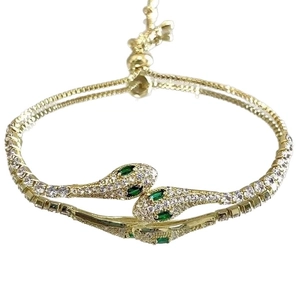 Gold plated snake bracelet featuring pavé zircon stones and green gemstone eyes