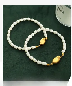 Detailed view of natural freshwater pearl bracelet with golden oval clasp on dark green background