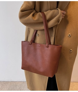 Close-up of a large reddish brown tote bag with premium lychee grain texture details