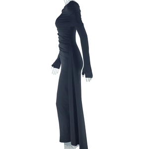 Detail of waist pleats and slim fit silhouette on black long sleeve asymmetric dress
