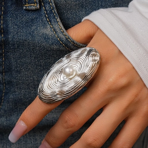 Detail of oval ripple ring featuring a large faux pearl in a silver metallic finish
