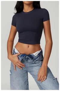Detail of navy blue slim fit crop top paired with distressed light blue denim jeans