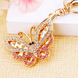 Macro detail of golden crystal butterfly keychain with pink rhinestones and hollow wings