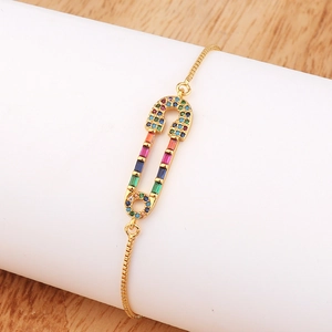 Detail of gold safety pin bracelet with multi-colored cubic zirconia stones and adjustable clasp