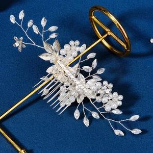 Detailed shot of handmade silver bridal hair comb with pearls and crystals on metal leaves