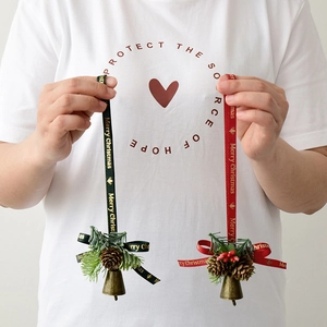 Christmas tree ornaments set with metal bells pine cones and Merry Christmas ribbons