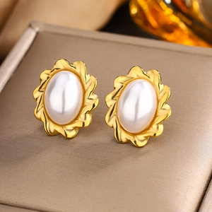 Macro shot of 18K gold plated heart earrings with white pearls and twisted rope texture