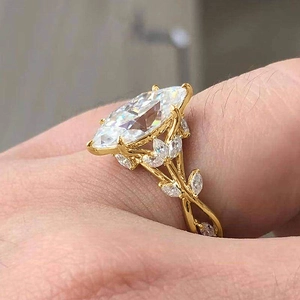 Luxury gold ring with marquise-cut zircon and leaf vine pattern, side view macro detail