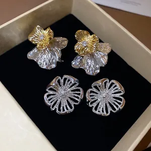 Elegante Blumen-Ohrstecker aus Gold und Silber mit Strass auf schwarzem Samt präsentiert
