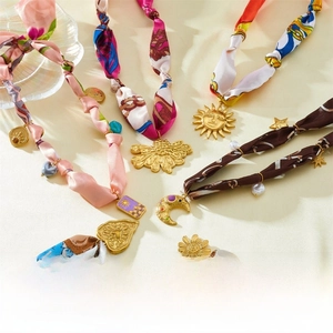 Vue détaillée des pendentifs dorés avec rubans en soie colorés et motifs de bijoux variés