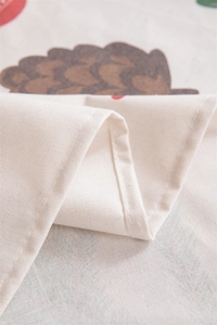 Close-up of linen-cotton fabric featuring a brown hedgehog pattern and stitched edge