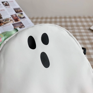 Gros plan sur le sac bandoulière en toile blanche avec motif minimaliste de fantôme noir