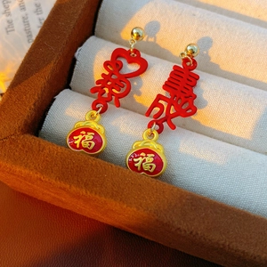 Detail of vintage red enamel tassel earrings with gold Chinese lucky characters