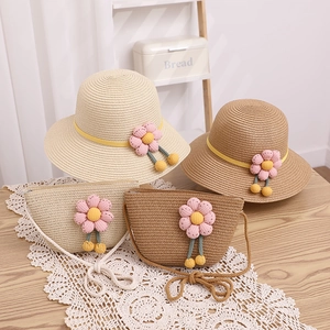 Détail d'un ensemble chapeau et sac en paille pour enfant avec fleurs tricotées
