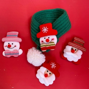 Detail of green knitted Christmas pet scarf with cartoon snowman and Santa patches