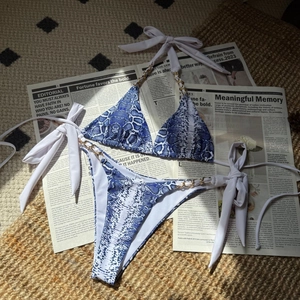 Gros plan du bikini imprimé serpent bleu avec détails de chaînes dorées élégantes