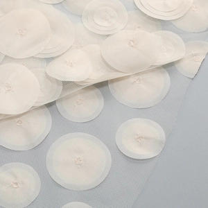 Detailed close-up of 3D polka dot appliques on elegant mesh fabric for strapless dress