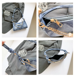 Dettaglio della borsa a mezzaluna in denim con catena di perle e tracolla con nodo