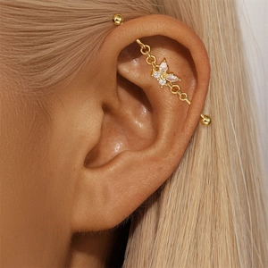 Detailed close-up of a gold butterfly industrial piercing bar with sparkling zircons