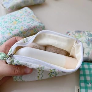 Détail de la mini pochette en coton à fleurs montrant la fermeture éclair et l'intérieur
