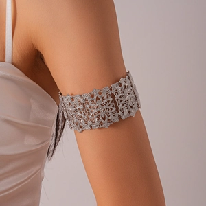 Détail d'un bracelet de bras ajouré argenté avec strass brillants porté au bras