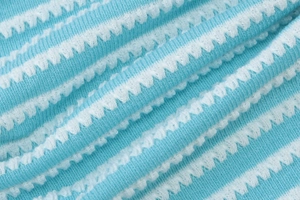 Close-up of blue and white striped seersucker fabric with high-textured bumpy finish