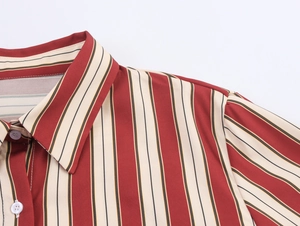 Détail du col à revers classique et des boutons sur une chemise à rayures rouge et beige