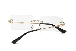 Back view of rimless rectangular sunglasses with gold metal frame and black temple tips
