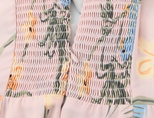 Détail d'une robe fleurie rose avec tissu élastique froncé et fermeture éclair invisible