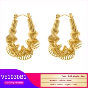 Detail showing twisted gold-plated stainless steel C-shape earring with spiral texture