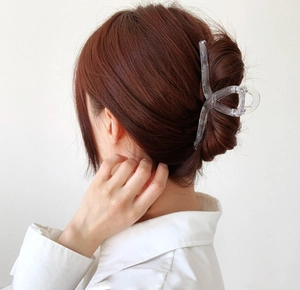 Detail view of large transparent square hair claw clip in a stylish twisted design