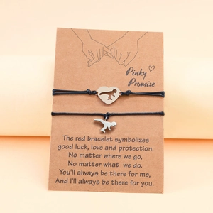 Couples dinosaur charms on handwoven ropes presented on a Pinky Promise card